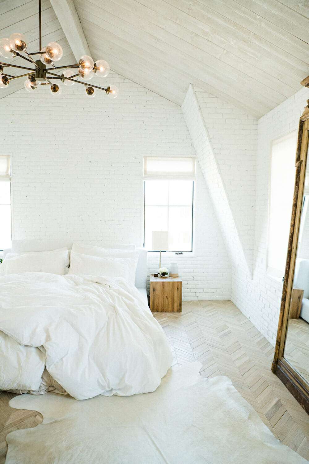 Minimalistisches Schlafzimmer mit goldenem Spiegel