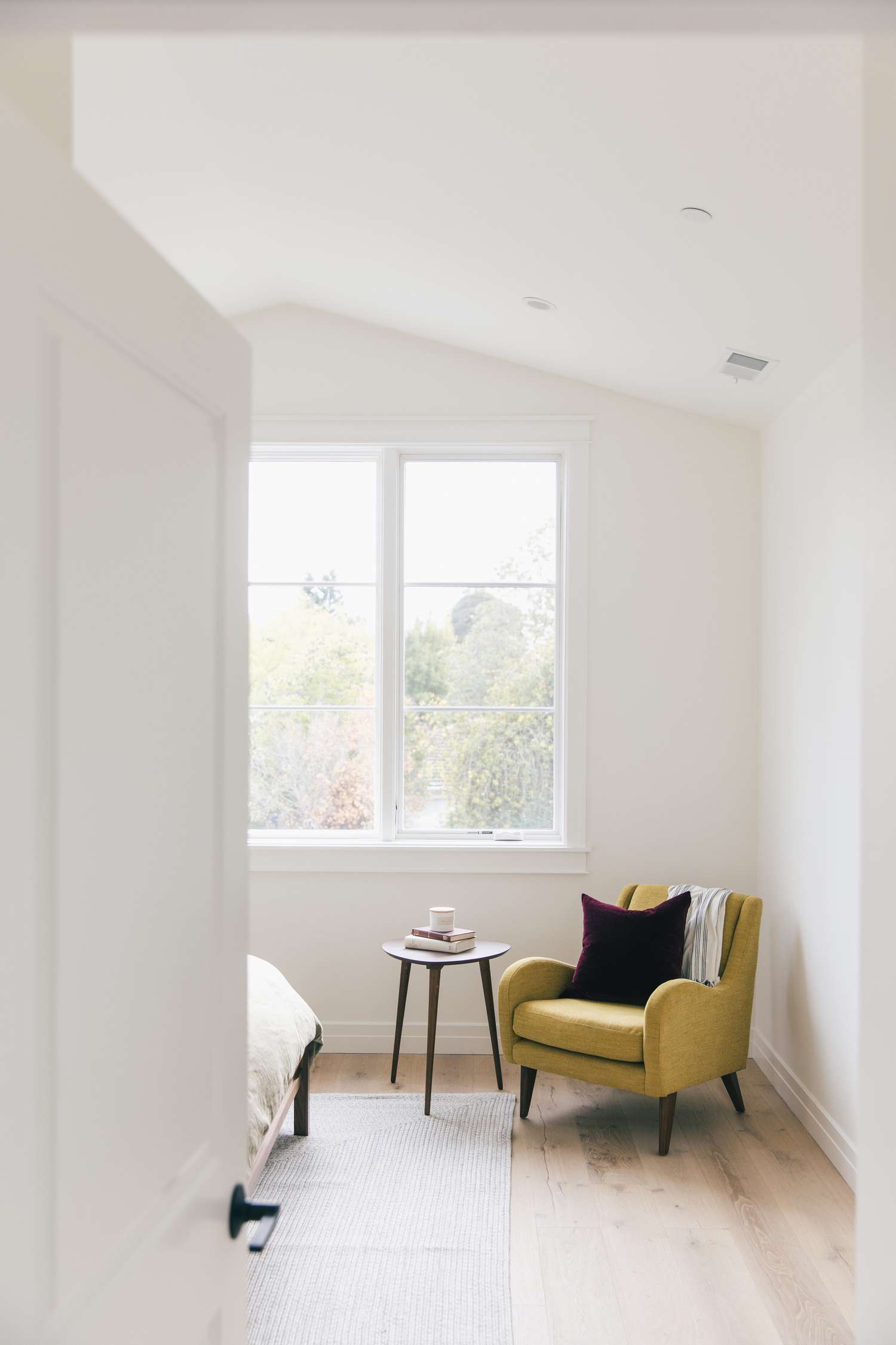 Minimalistisches Schlafzimmer mit gelbem Sessel