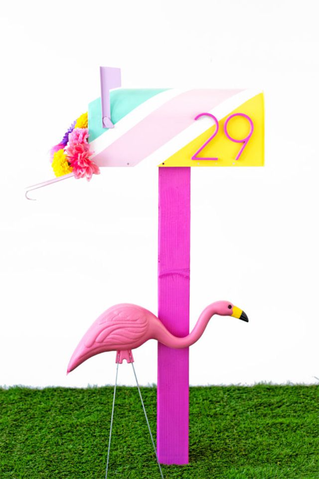 Ein rosa gestreifter Briefkasten mit einem Flamingo aus Plastik