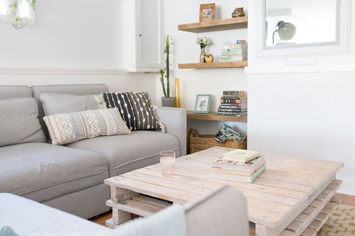 Wohnzimmer im Untergeschoss mit Couch, Couchtisch und Regalen.