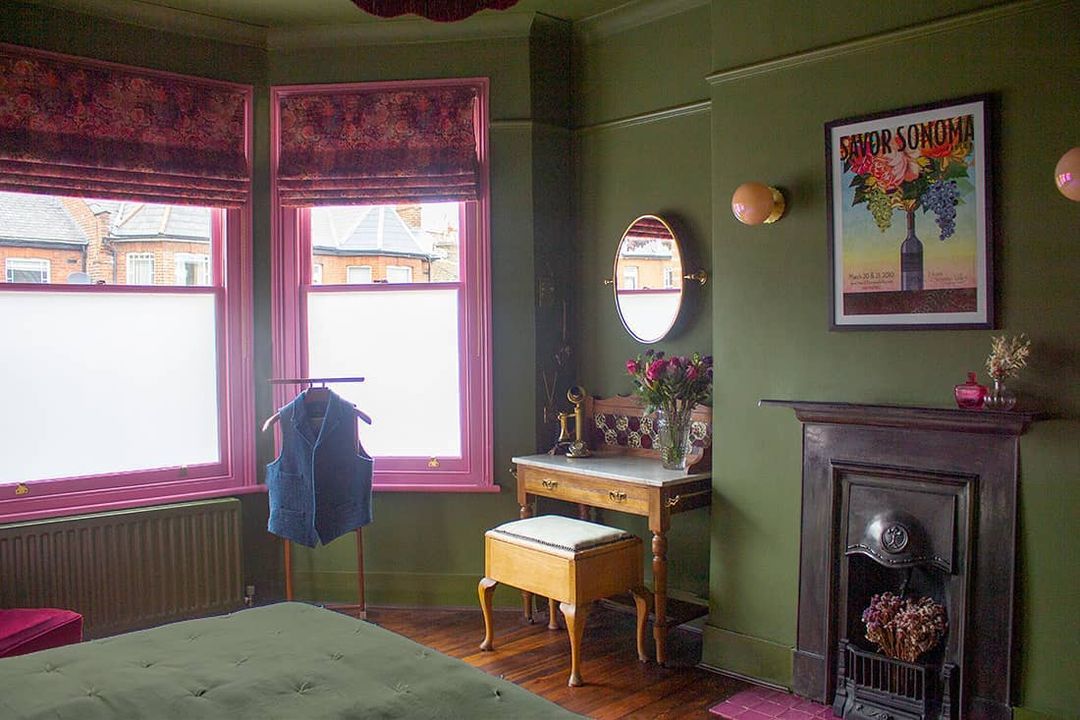 Dunkelgrünes Schlafzimmer mit floral gemusterten Raffrollos