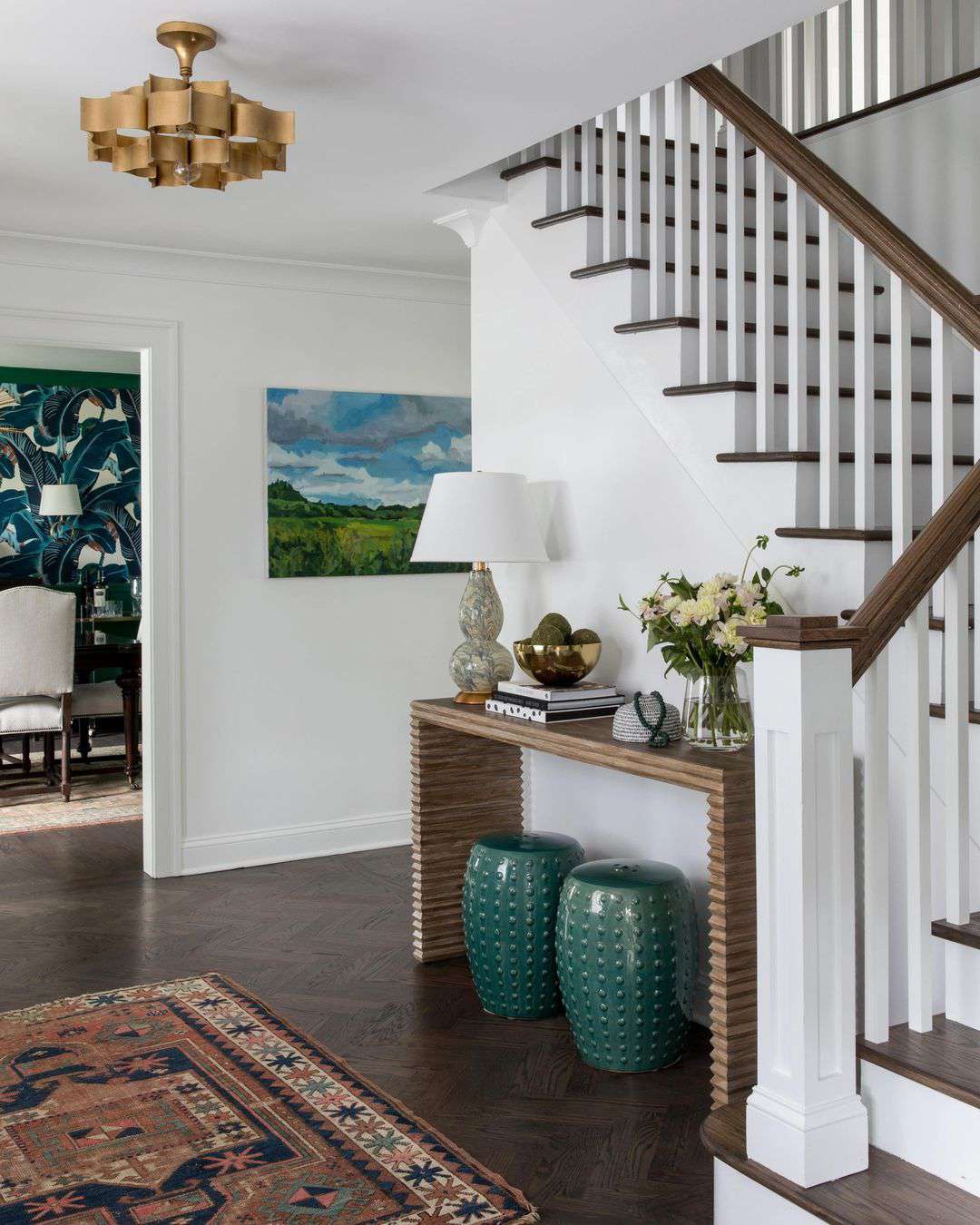 Entryway with gold sculptural light fixture.