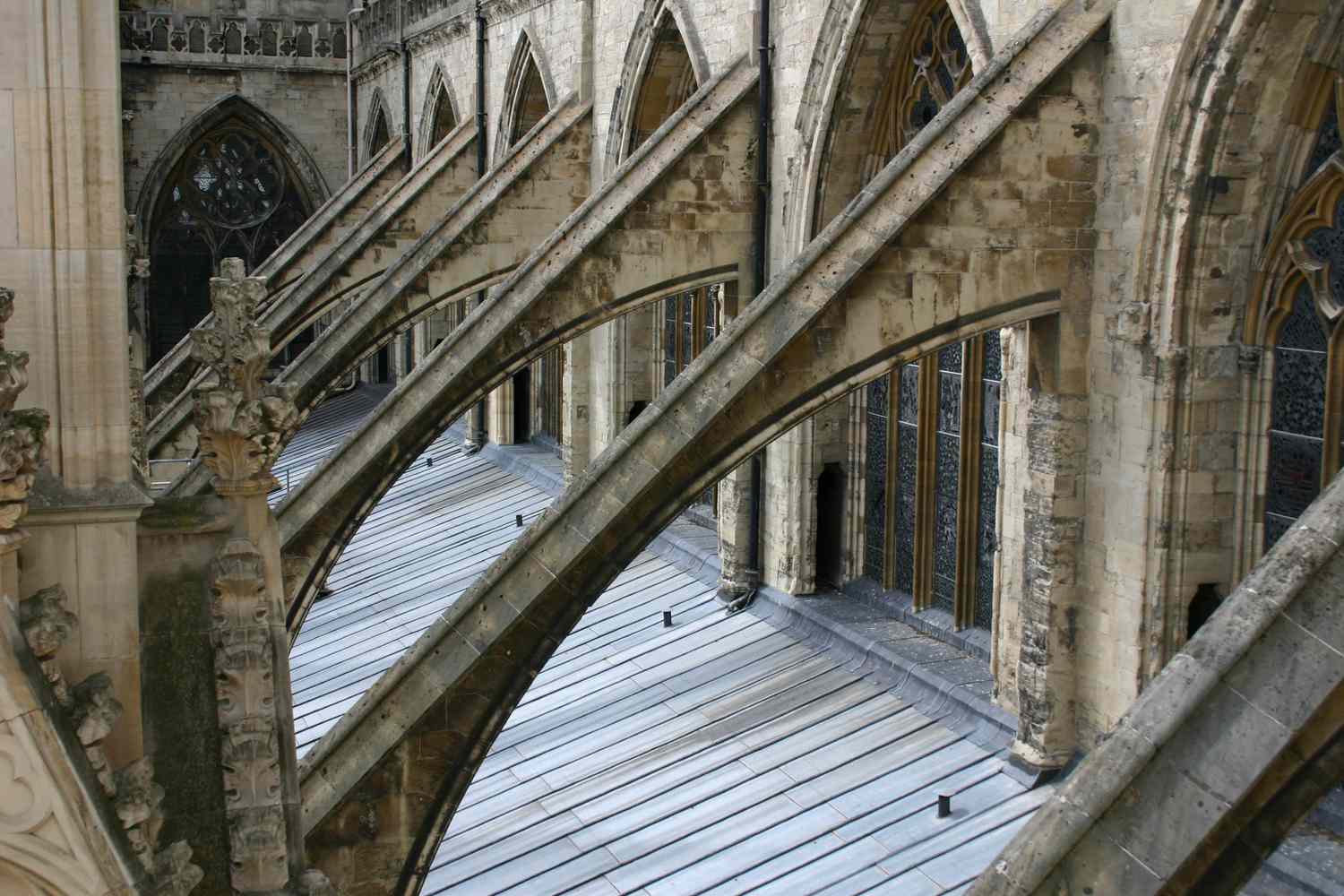 Nahaufnahme des Strebepfeilers mit gewölbter Strebe von einer Außenwand zur Wand einer Kirche