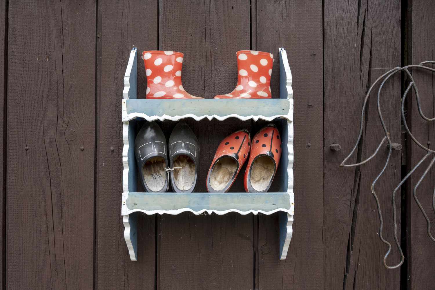 A wall shelf holding outdoor shoes