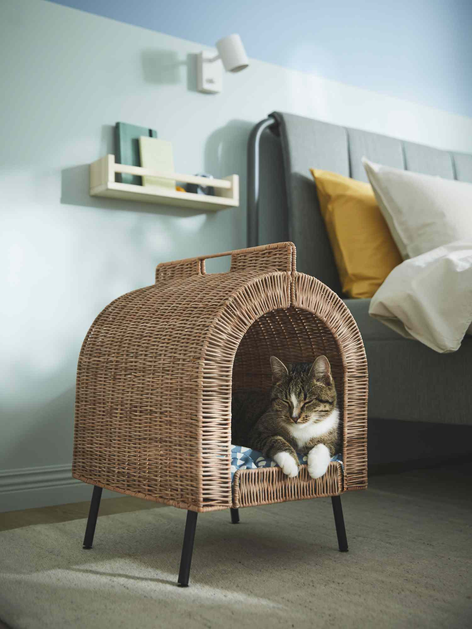 Braun und weiße Katze, die im Ikea Wicker Cat House schläft