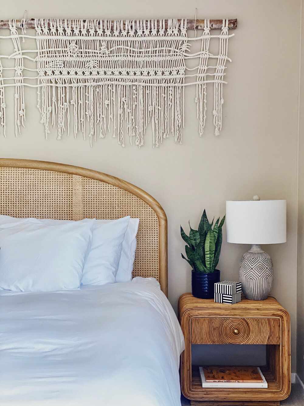 boho-style macrame wall hanging over bed