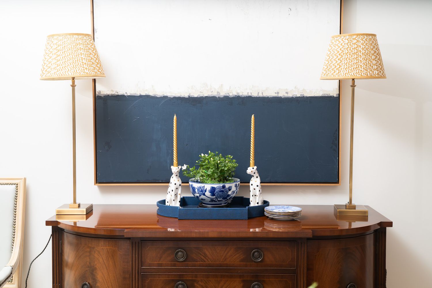 hölzerne Sideboard mit blau -weißer Keramik und gemusterten Lampen oben