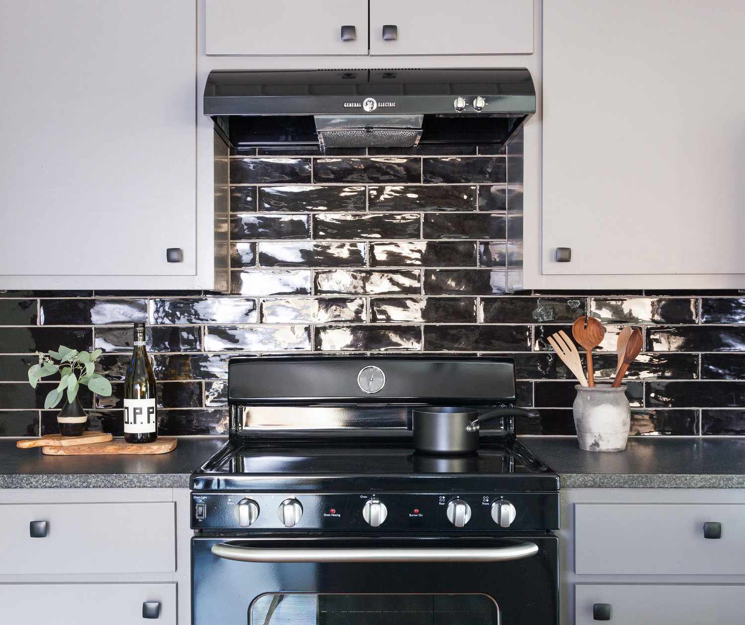 light gray kitchen with black backsplash