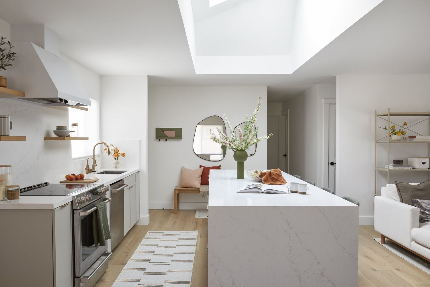 Modern kitchen with waterfall island and living room on the right