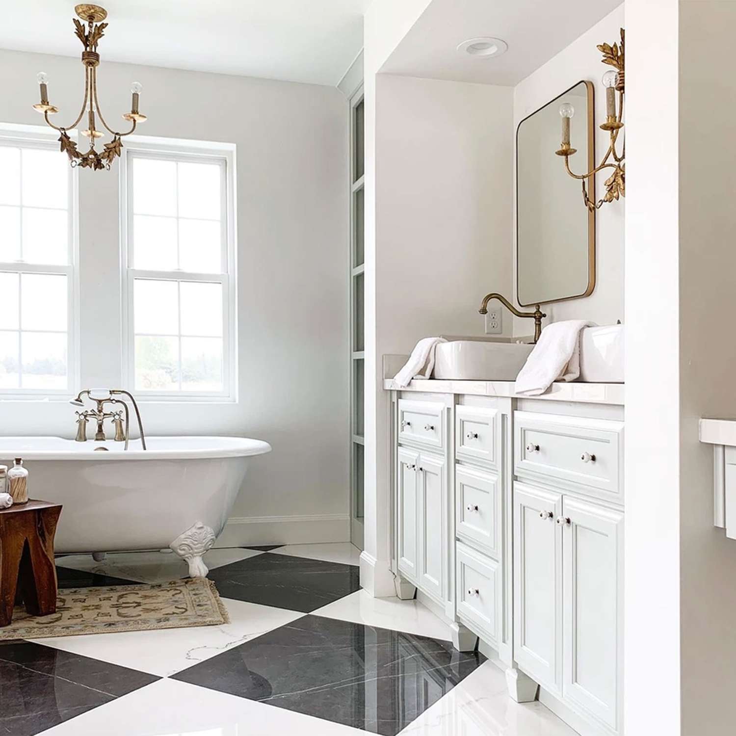 Ashley Webb Interiors bathroom with multiple lighting sources, clawfoot tub, vessel sink, and ample storage.