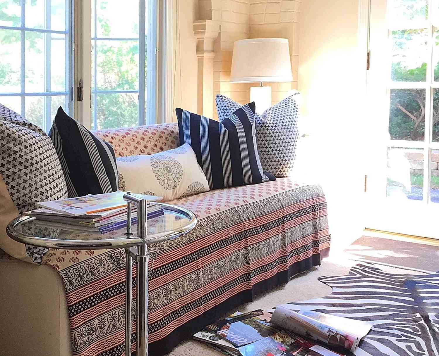 Daybed with patterned throw, pillows, and rug in a bright sunroom