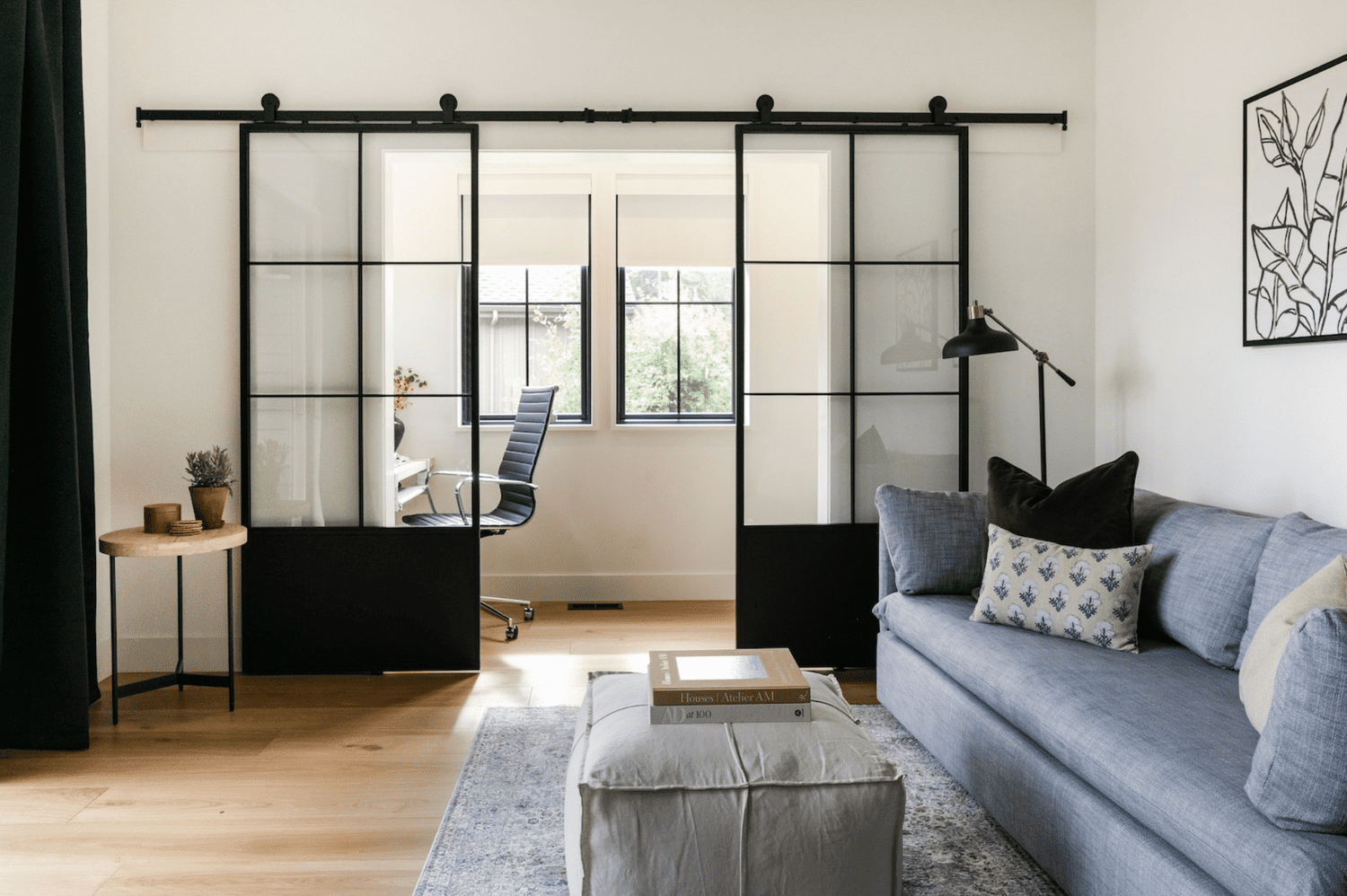 Black metal and glass grid sliding doors separating living room and sunroom