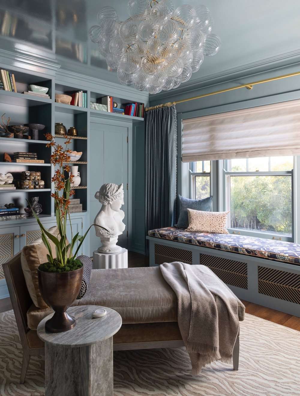 Built-in window seat in a sunroom with gray-blue walls