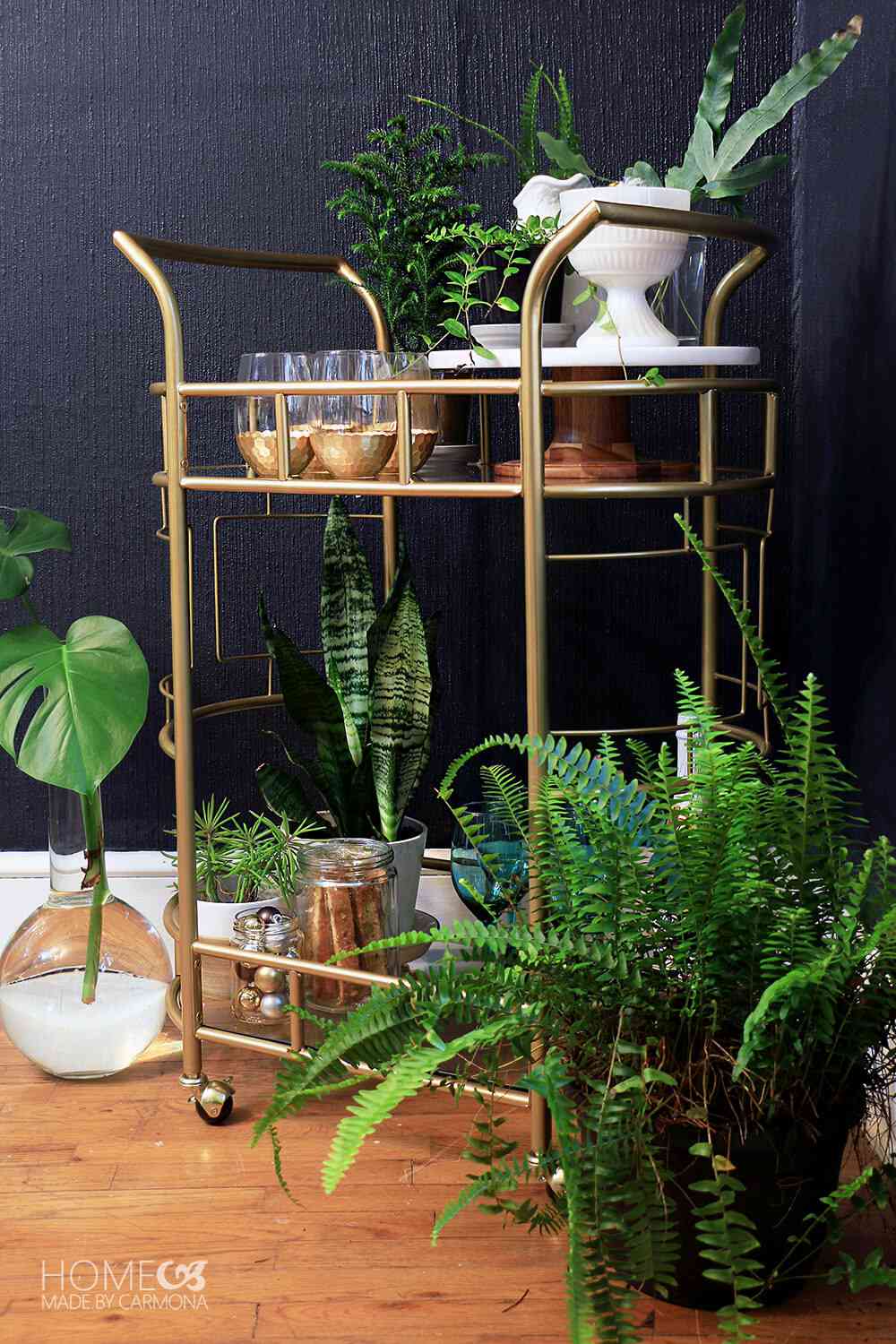 Gold bar cart styled with drinkware, accessories and potted plants