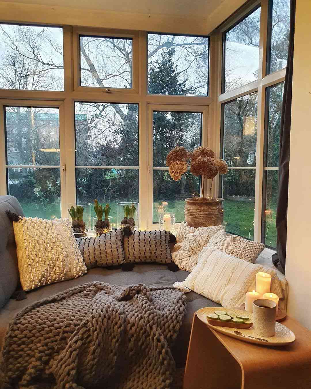 Plants and candles displayed on a sunroom window sill