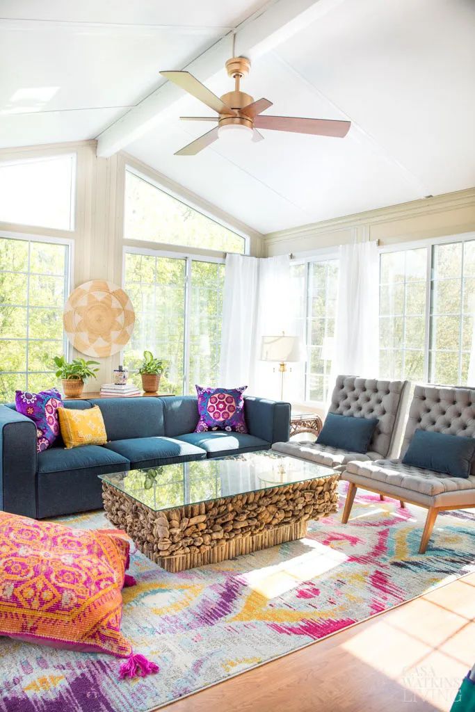 Colorful sunroom with a wood coffee table, navy sofa and gray accent chairs