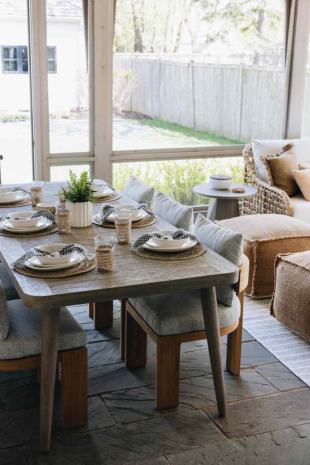 Wood dining table and upholstered chairs in a modern rustic sunroom