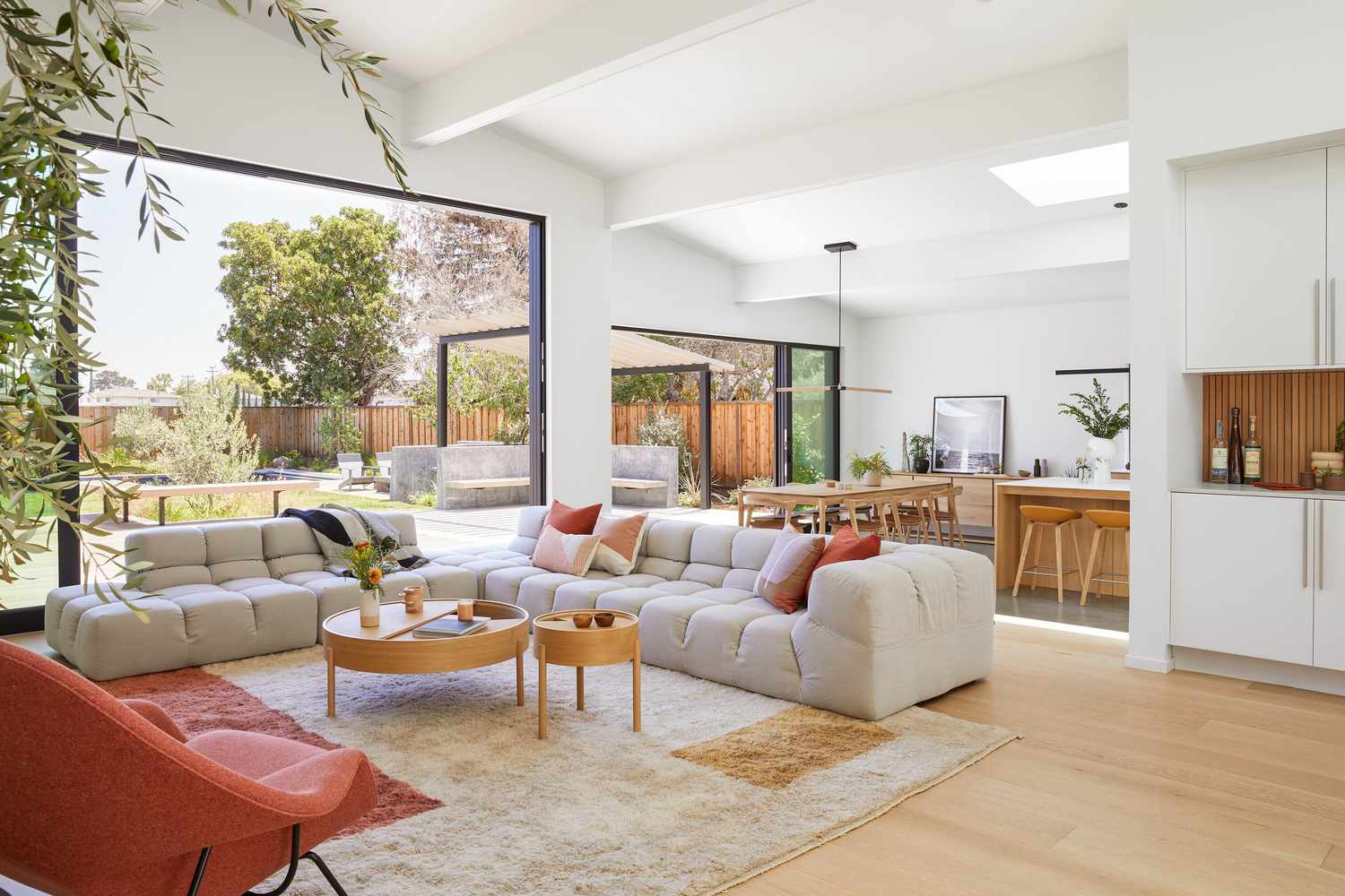 Open living, dining room and kitchen with white walls and hardwood floors