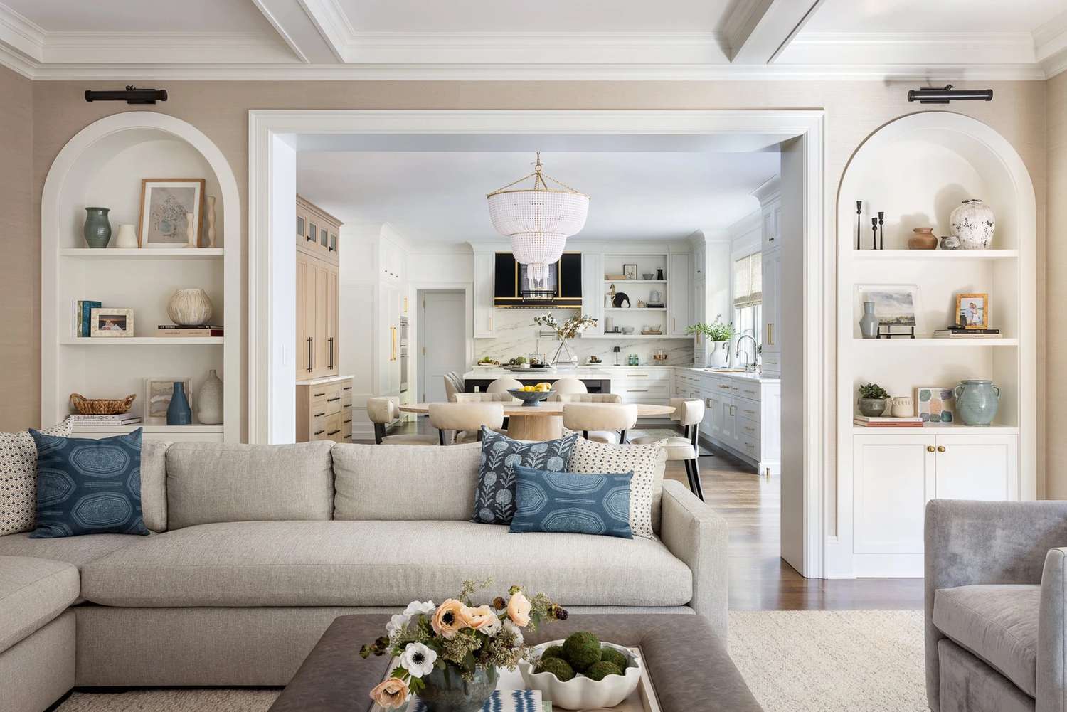 Living room with built-in shelves with kitchen in the background